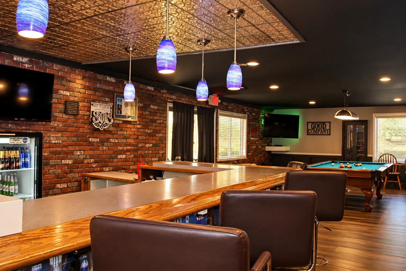 The Bistro bar and lounge, with leather bar stools, a brick wall and a pool table beyond