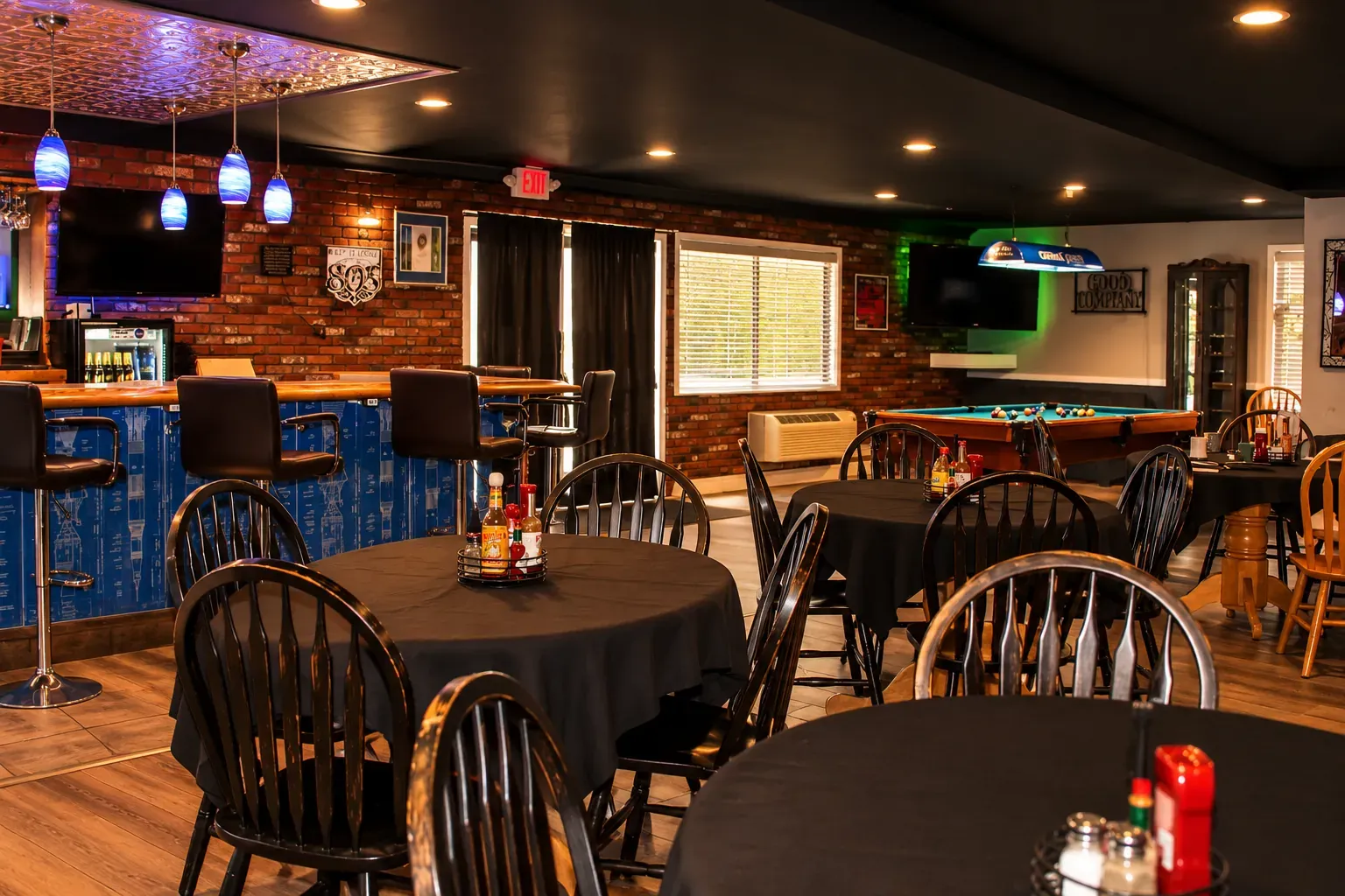 Inside O'Cairns Bistro: dining tables in front of the bar, with the lounge beyond