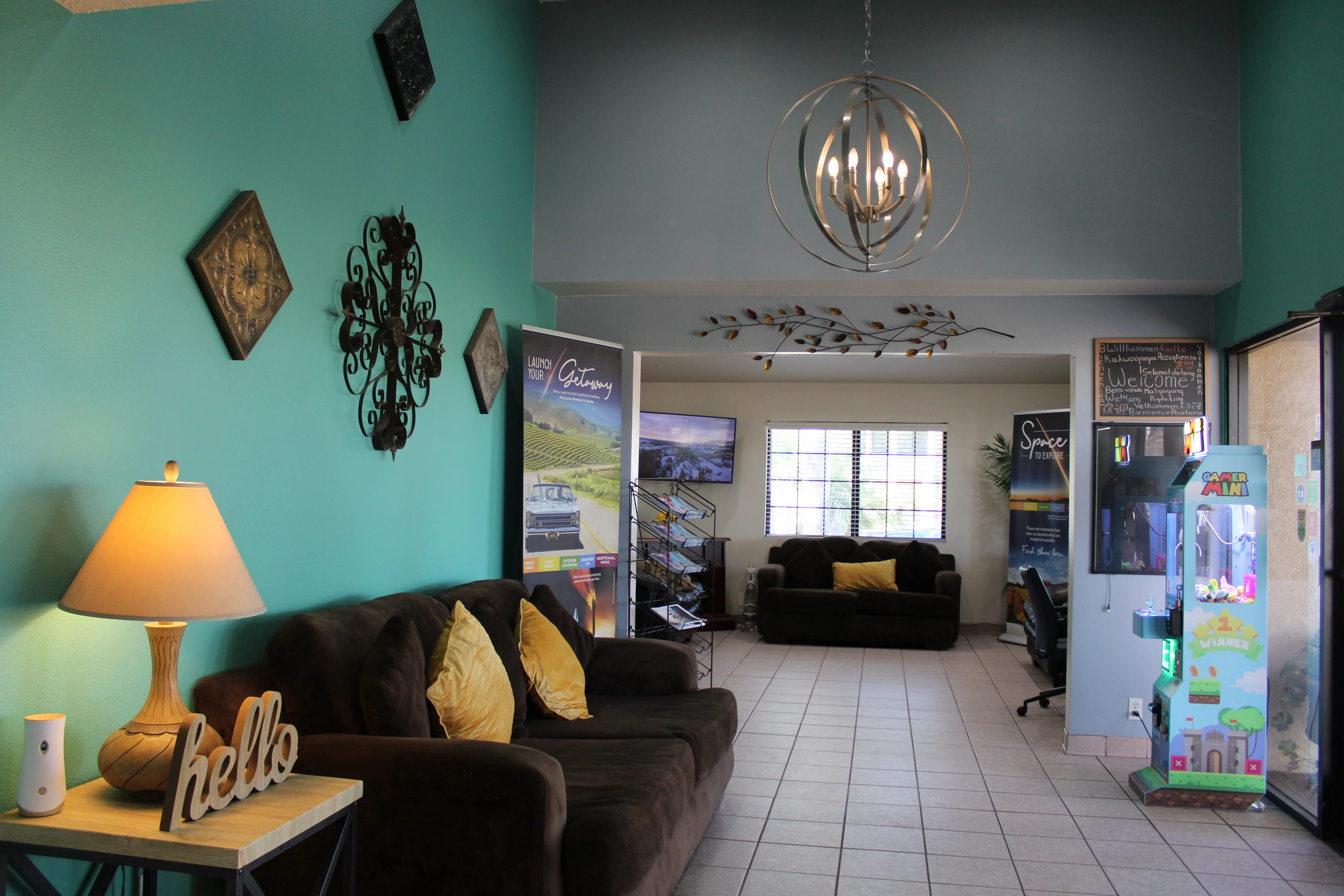 The lounge leading into the business center, with couches, a brochure rack and a wall-mounted television
