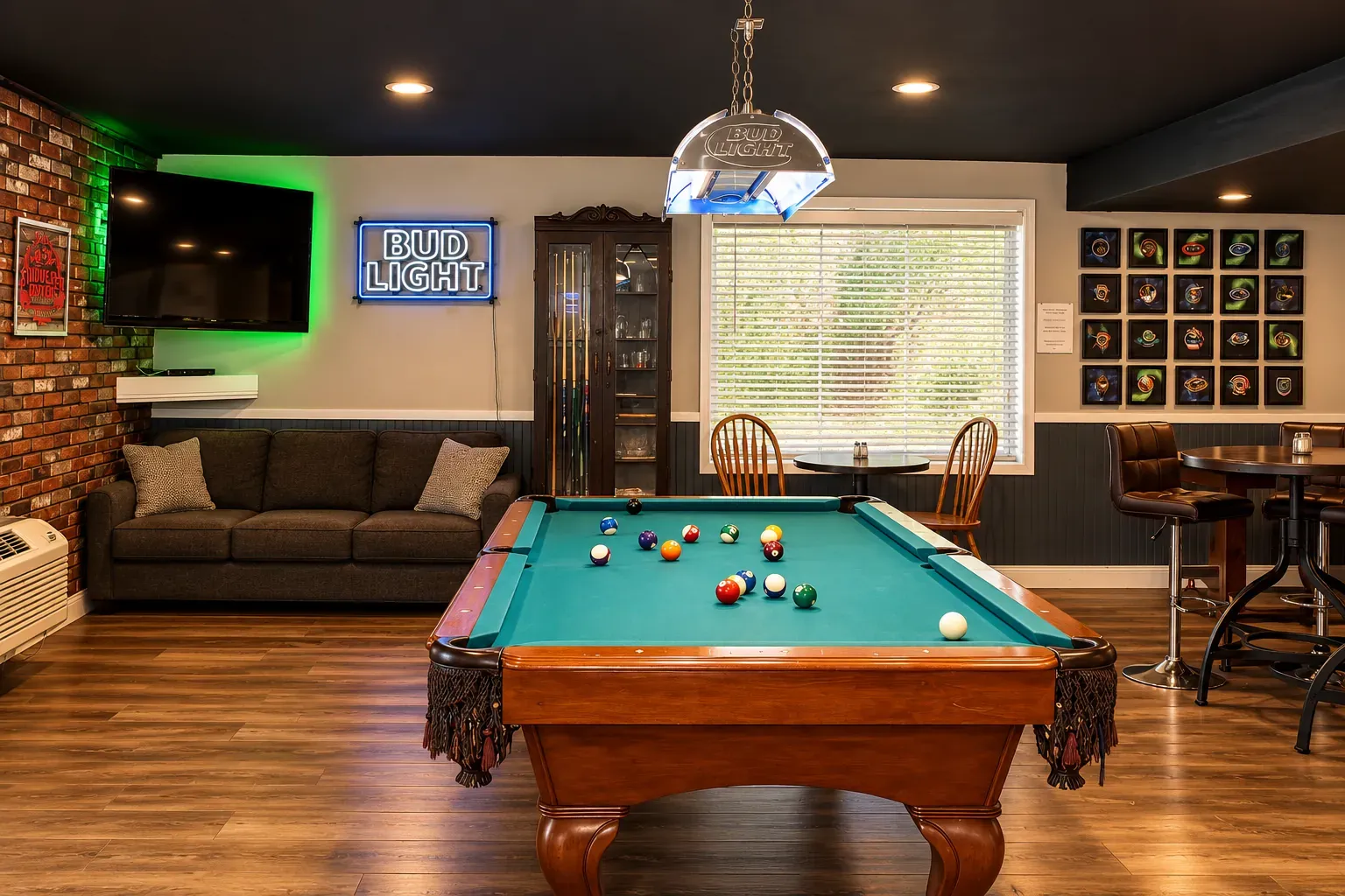 A pool table in the lounge, with a sofa and a wall-mounted television