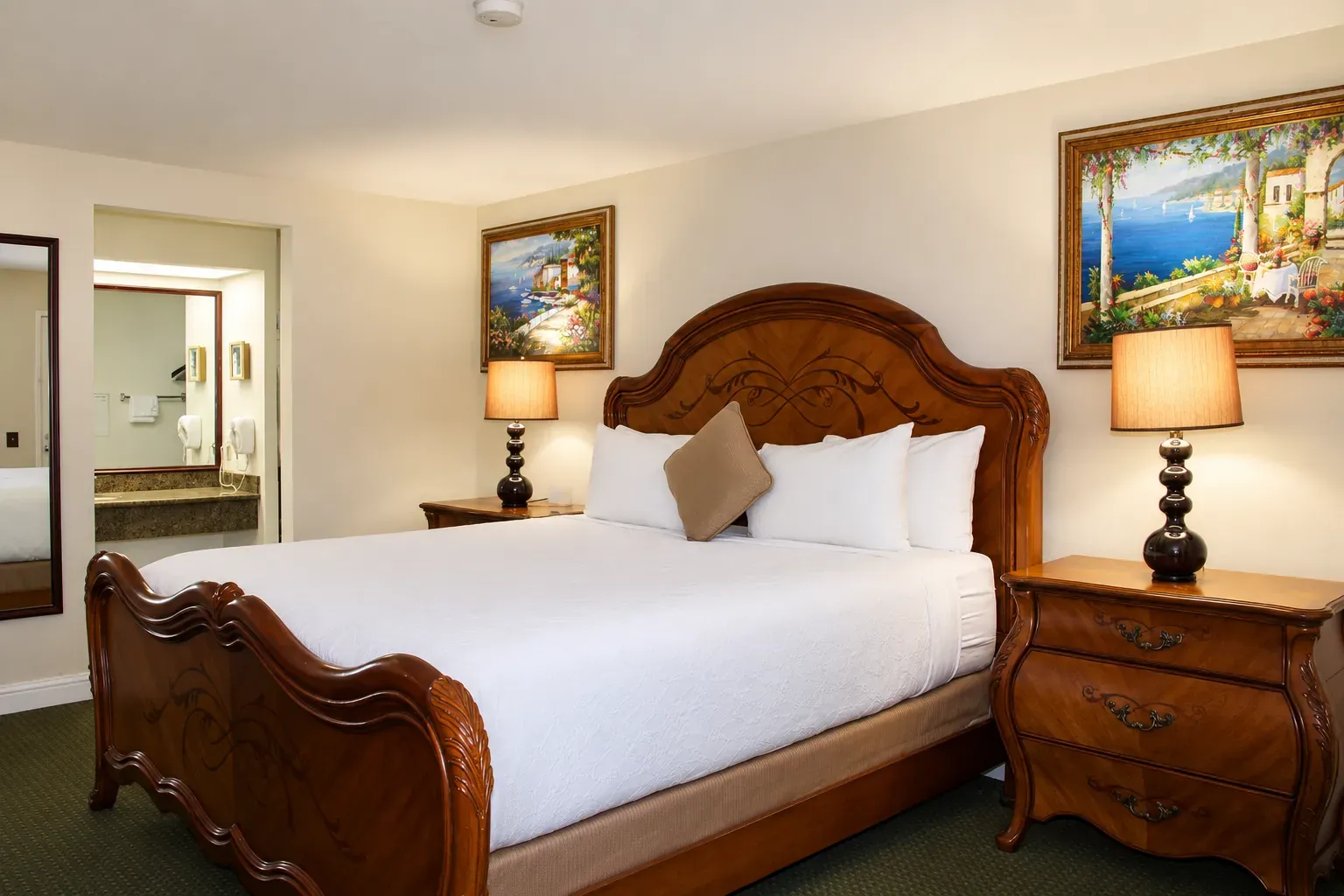 The suite's bedroom: a carved wooden bed with nightstands and lamps